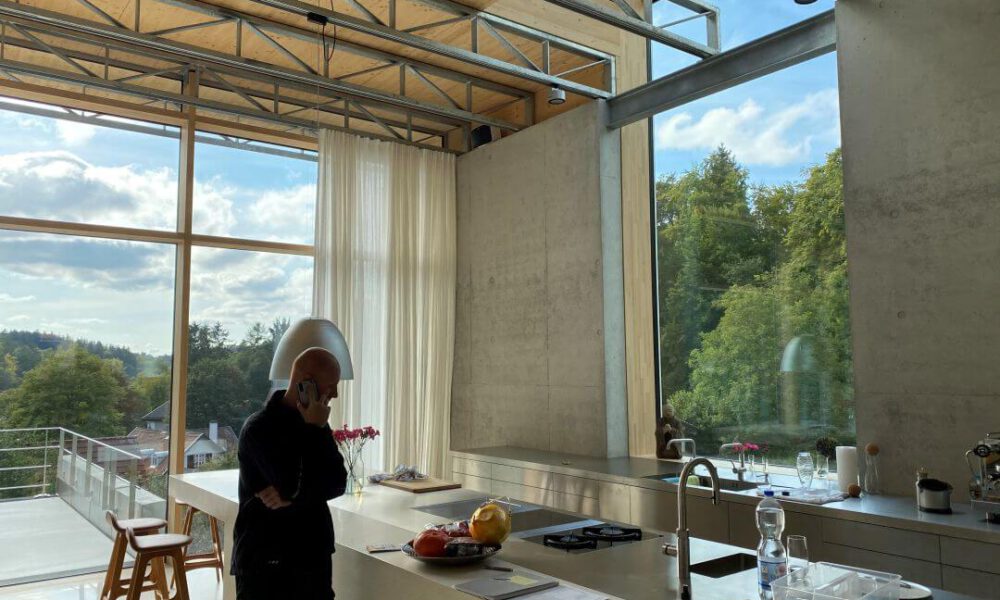 Referenzbild einer Kundenanlage - Die Küche einer Villa mit Sichtbetonwänden und Smarthome Ausstattung